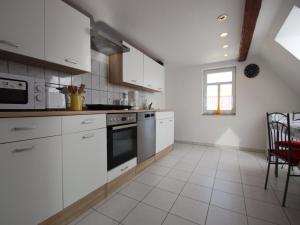 a kitchen with white cabinets and a stove top oven at behagliche Ferienwohnung in Elbingerode in Elbingerode