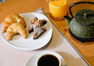 a plate of croissants and a cup of coffee on a table at Gluck Patagonia Aparts in Villa La Angostura +26 photos
