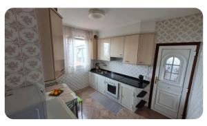 a small kitchen with white cabinets and a door at Casa Lali in Redondela