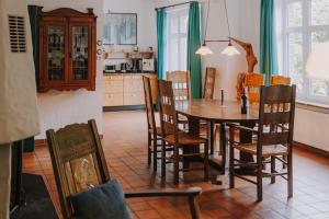 a kitchen with a dining room table and chairs at Friesenpark 8 in Wurster Nordseeküste +22 photos