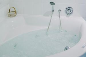 a bath tub filled with water with a shower at Friesenpark 8 in Wurster Nordseeküste