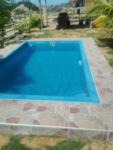 a swimming pool in a yard with a tiled floor at Casa verde in Vichayito