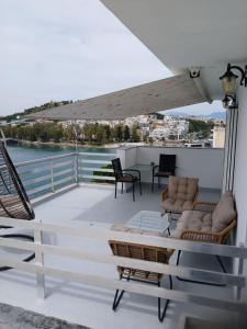 a balcony with chairs and a table on a roof at Demetrius's Penthouse in Chalkida