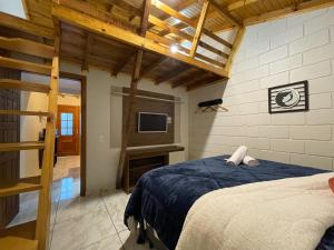 a bedroom with a bed and a tv in it at Sentiero Lofts in Urubici