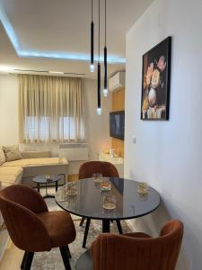 a living room with a table and chairs and a couch at Altura Garden 1 in Vrnjačka Banja