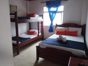 a bedroom with two bunk beds and a window at Hotel Girasol in Santa Rosa de Cabal