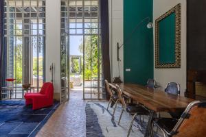 a dining room with a wooden table and a red chair at Villa ouidane in Marrakesh