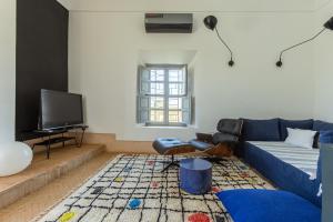 a living room with a blue couch and a tv at Villa ouidane in Marrakesh