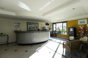 a large lobby with a bar in a building at Golfinhos Apart Hotel in Florianópolis +127 photos