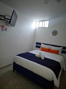 a bedroom with a large bed with orange and blue pillows at Hotel Girasol in Santa Rosa de Cabal +7 photos