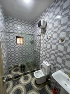 a bathroom with a shower and a toilet and a sink at Goshen in Iju Junction +6 photos