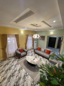 a large living room with couches and a table at Goshen in Iju Junction