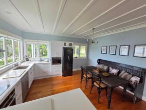 a kitchen with a table and a dining room at Kingfisher Lodge Waterfront Retreat in Tairua