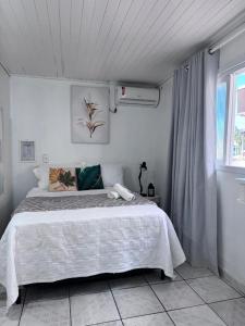 a bedroom with a large bed in a white room at Pousada Vô Francisco in Torres