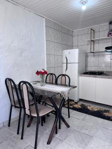 a kitchen with a table with chairs and a refrigerator at Pousada Vô Francisco in Torres +82 photos