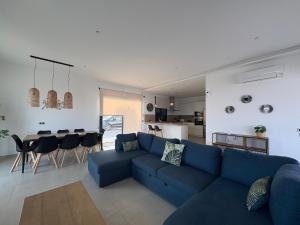 a living room with a blue couch and a table at Vivienda en Granada, Cortijo Balcón Cotobro, Almuñécar, Casa con piscina y vistas increíbles in Granada