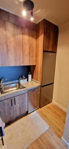 a kitchen with wooden cabinets and a stainless steel refrigerator at Apartament La Torre in Torrevieja