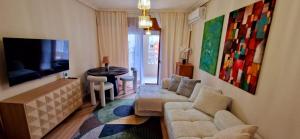 a living room with a couch and a tv and a table at Apartament La Torre in Torrevieja
