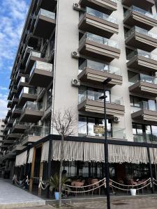 a tall apartment building with awnings in front of it at Holiday apartaments Gaca in Lezhë