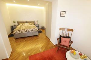 a bedroom with a bed and a chair in it at House PUNTA II in Umag