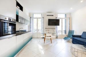 a kitchen and living room with a couch and a table at Maison Carnot in Cannes