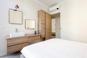 a bedroom with a white bed and a sink at Maison Carnot in Cannes