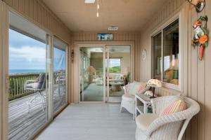 a porch with wicker chairs and a balcony at A Searious Sunset View by Oak Island Accommodations in Caswell Beach +81 photos