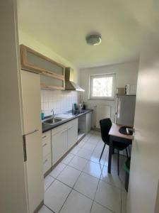 a kitchen with a sink and a table and a refrigerator at Wohnen Nähe Salzgittersee in Salzgitter