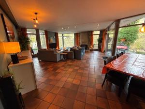 a living room with couches and tables and windows at Domaine Heyen in Waimes