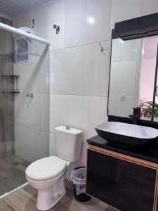 a bathroom with a toilet and a sink and a shower at Pousada Vô Francisco in Torres