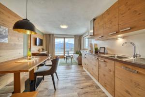 a kitchen with wooden cabinets and a table and a dining room at Gattererhof in Schenna