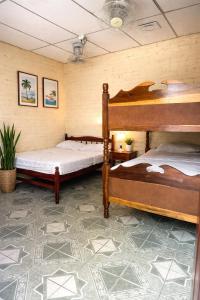 a bedroom with two bunk beds and a tile floor at Hostal Los Chamos in San Juan del Sur