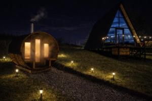 a lit up building with lights in a field at night at Cabaña Con Impresionante Vista Volcan y Lago AYUN LAFQUEN in Villarrica