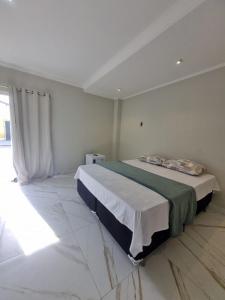 a bedroom with a large bed in a white room at Hotel Avalon in Benevides