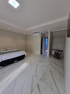 a bedroom with a bed and a marble floor at Hotel Avalon in Benevides