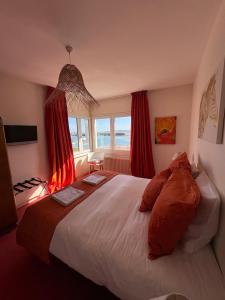 a bedroom with a large bed with red curtains at La parenthèse du port in Perros-Guirec