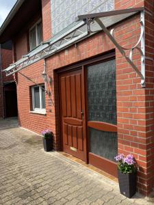 a brick building with a door and two potted plants at Perfect for longer stays in Heinsberg