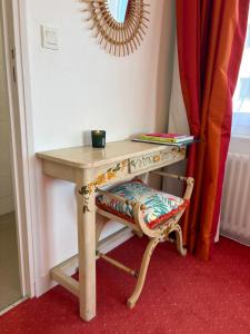a wooden table with a chair next to a table at La parenthèse du port in Perros-Guirec