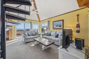 a living room with two couches and a tv at 7026 - Southwind in Rodanthe