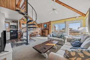 a living room with a spiral staircase in a house at 7026 - Southwind in Rodanthe