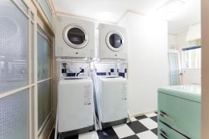 a laundry room with two washer and dryers in it at 全室オーシャンビューの宿 ルーチェ須崎 in Shimoda