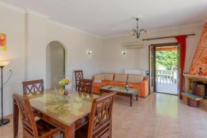 a dining room and living room with a table and chairs at Pothos Villas in Zakynthos