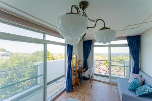 a living room with a couch and a large window at 全室オーシャンビューの宿 ルーチェ須崎 in Shimoda