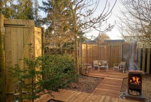 a backyard with a wood deck with a fire pit at La tiny house perdue in Saint-Blimont