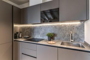 a kitchen with white cabinets and a sink at Seety Spartaco in Milan