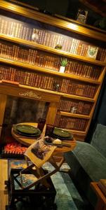 a table and a chair in front of a book shelf at La tiny house perdue in Saint-Blimont