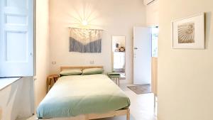 a small bedroom with a bed and a chandelier at OSA - Stella - Garden Hostel with bar in Naples