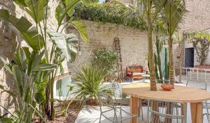 a patio with a wooden table and some plants at OSA - Stella - Garden Hostel with bar in Naples