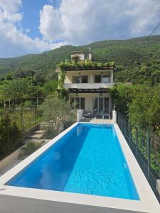 a villa with a swimming pool in front of a house at VanjAna in Đenovići