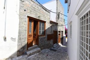 ein Steingebäude mit Holztüren an einer Straße in der Unterkunft Hydra's Ideal Accommodation in Hydra